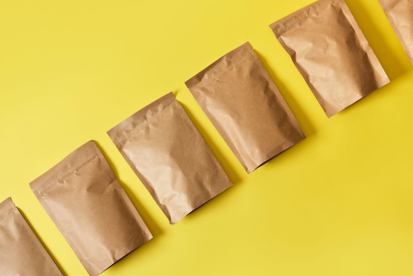 Caja de cartón ecológica con el texto 'Frustration Free Packaging' en un entorno de almacén, simbolizando la facilidad de