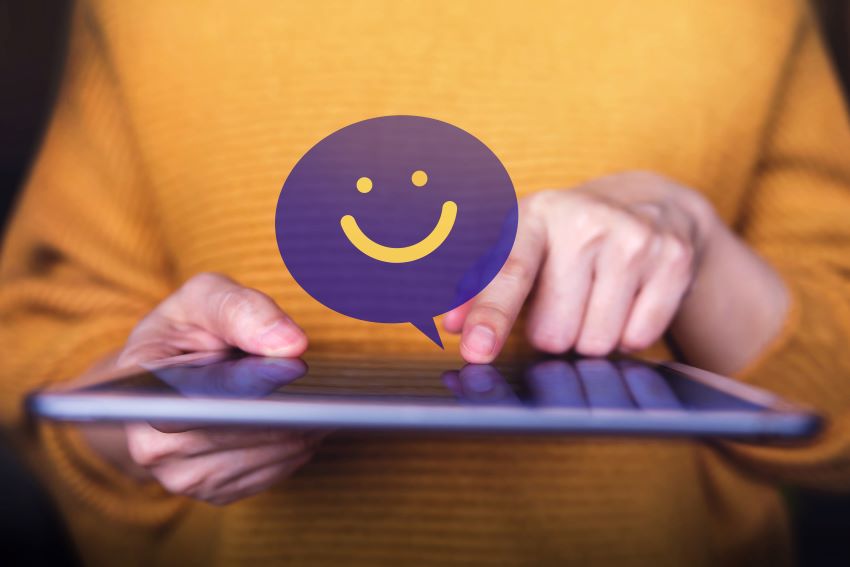 Cliente sonriendo y usando una tarjeta de crédito en una tablet, símbolos de e-commerce y candados inteligentes alrededor