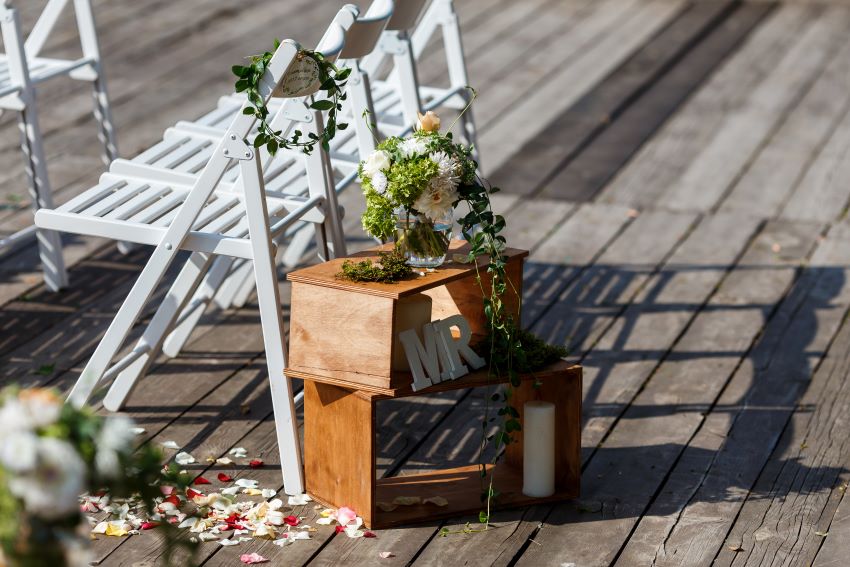 Una pareja de novios sonriendo y dándose la mano mientras observan una libreta plantable, simbolizando un detalle de boda