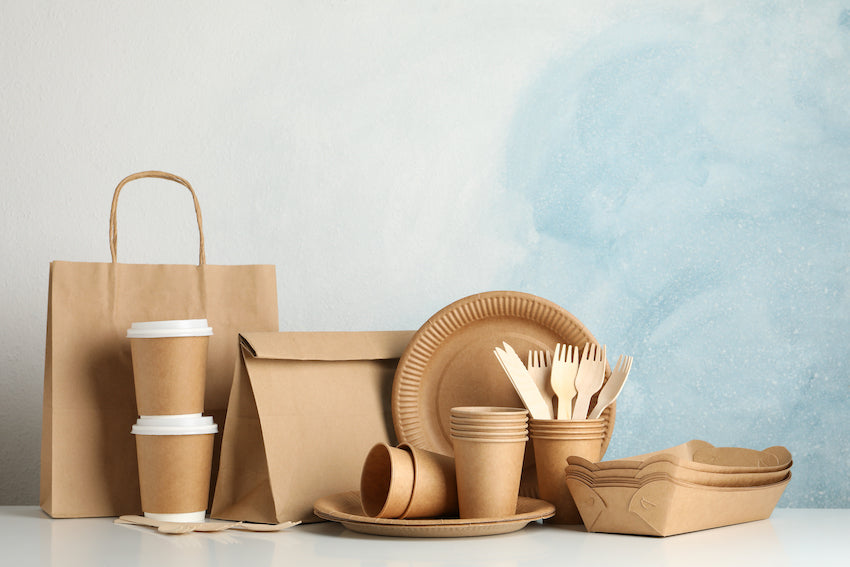 Una variedad de opciones de packaging ecológico, incluyendo cajas de cartón, bolsas de papel y materiales compostables,