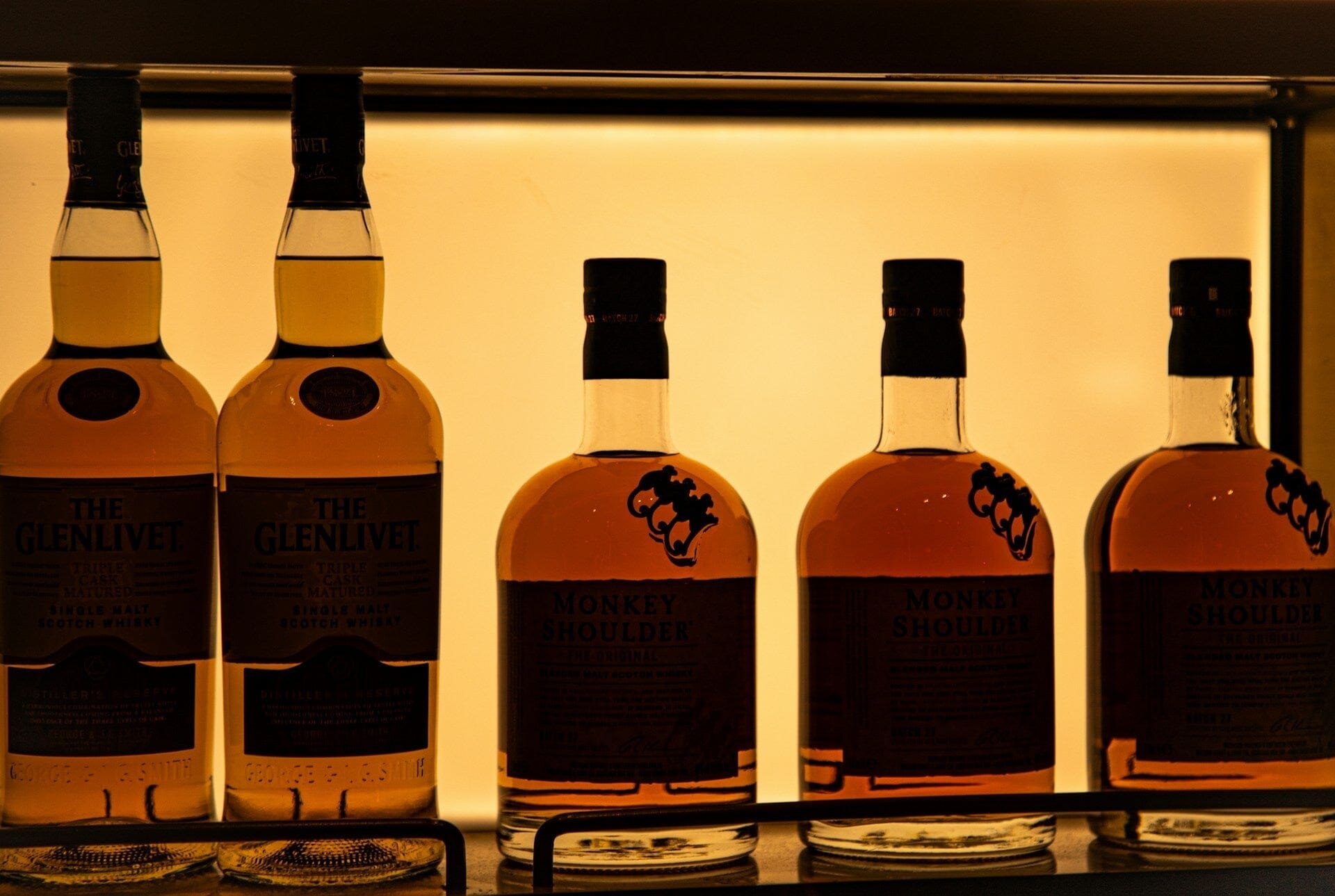 Botella de bebida premium con packaging elegante y distintivo sobre un fondo oscuro y sofisticado.