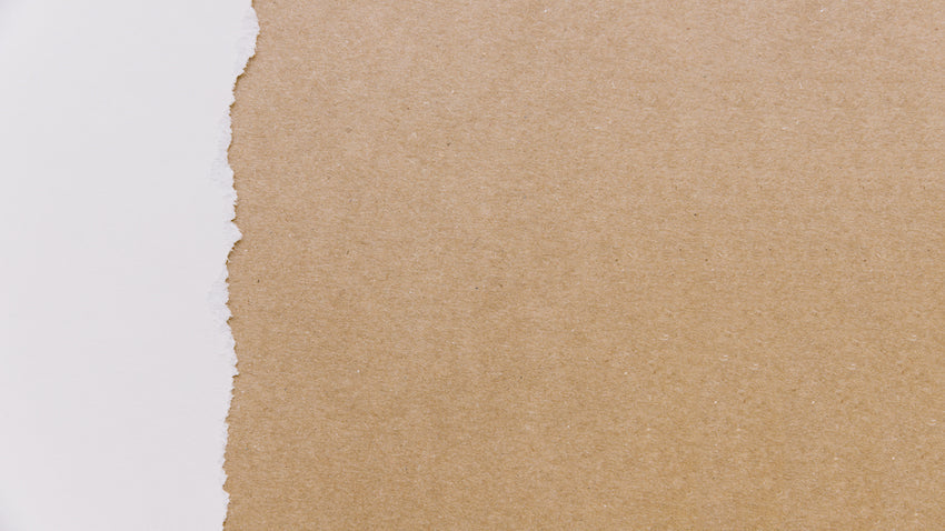 Caja envuelta en papel verjurado marrón con un lazo rústico, lista para un envío elegante y seguro