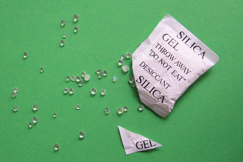 Varias bolsas de silica gel blancas sobre un fondo neutro, preparadas para proteger productos de la humedad.