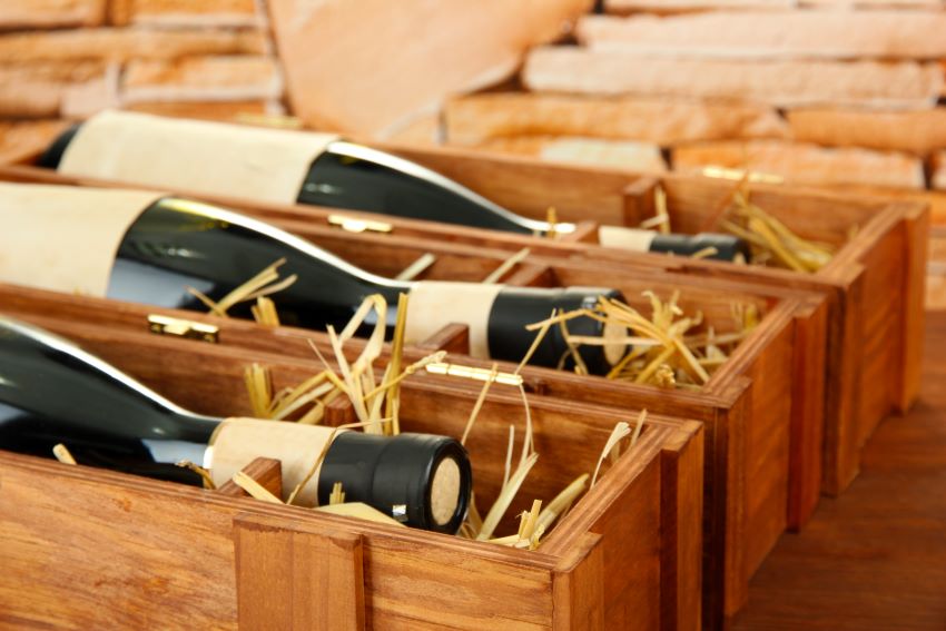 Botellas de vino tinto y blanco dentro de cajas de cartón con separadores, listas para transporte seguro